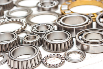 Bearings of all kinds and classifications on a white wooden background.