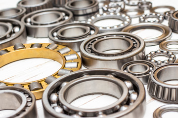 Bearings of all kinds and classifications on a white wooden background.