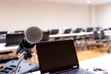 Microphone and Laptop on abstract blurred of speech in seminar room