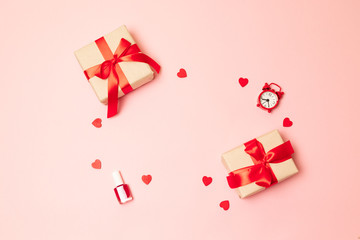 March 8, International Women's Day, Valentine's Day. Surprise gift boxes with a red ribbon bow, nail polish and a red clock on a pink background