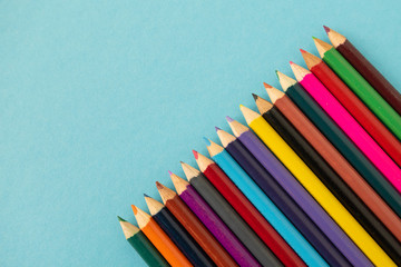 Fototapeta premium colored pencils on blue paper