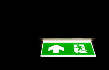 Green emergency exit sing in darkness