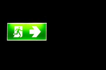 Green emergency exit sing in darkness