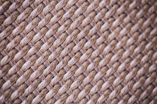 Brown artificial rattan pattern background of structure close-up. Furniture backdrop. Selective focus.