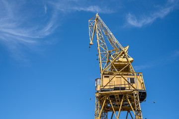 Fototapeta na wymiar Tall yellow construction crane with clear blue sky, tool or machine to lifting huge and heavy for industrial development