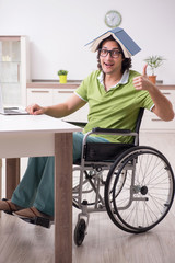 Young male student in wheelchair at home