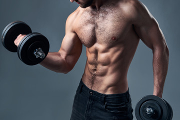 Fototapeta na wymiar Cropped portrait of strong shirtless sport man with dumbbells isolated