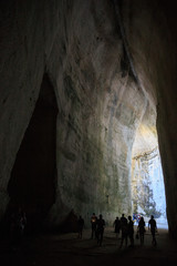 tourist silhouettes in the cave Ear of Dionysius , natural acoustic miracle