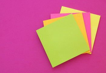 Colorful blank note papers on pink background  with room for text.