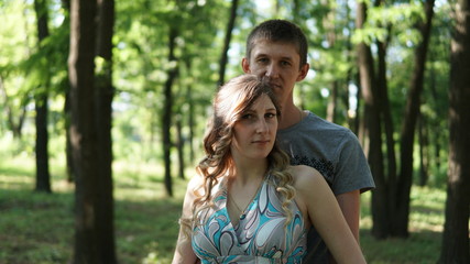 Portrait of a young couples in a summer park.