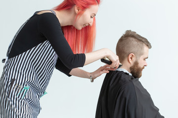 Hairdresser, stylist and barber shop concept - woman hairstylist cutting a man
