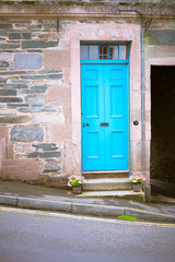Rustic and old fishermen house with carpentry painted blue door