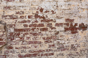 old shabby damaged plaster on the brick walls of houses close-up