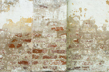old shabby damaged plaster on the brick walls of houses close-up