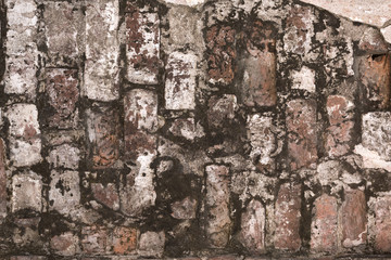 old shabby damaged plaster on the brick walls of houses close-up