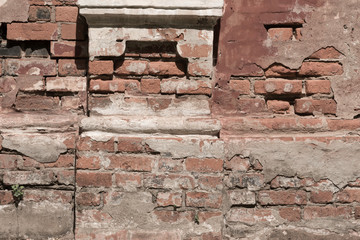 old shabby damaged plaster on the brick walls of houses close-up