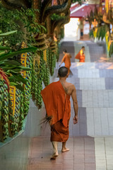 Mönch in einem buddhistischen Tempel geht  eine Treppe hinunter