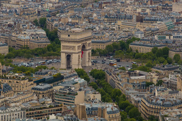 Great aerial view of the Arc de Triomphe de l'Étoile in Paris and the traffic on the roundabout of which the monument is the centre. Tourists walking at the base and on the roof of the arch.