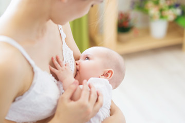Mother breast feeding her little boy. Mom nursing and feeding baby. Close-up portrait of infant