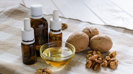 walnut oil with nuts on a light wooden table