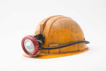 Old miner helmet with lamp on white background.