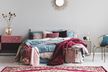 Sun shape like mirror above comfortable bed with cozy bedding