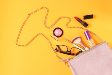 women's bag and cosmetics on a colored background