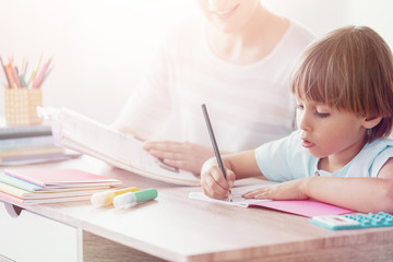 Boy drawing picture at desk during art classes in the school