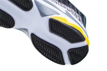 Fragment of a rubber black and white sole of a sneaker. Bottom of sports shoes