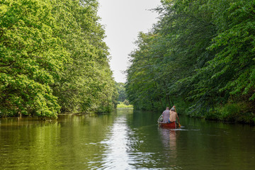 Fototapeta na wymiar People rowing in a canoe on the river at Vestbirk, Denmark