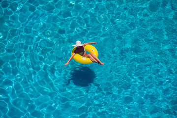 Woman swims on the inflatable circle in the pool. Summer and holiday concept