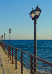 Street lights on sea pier on blue hour