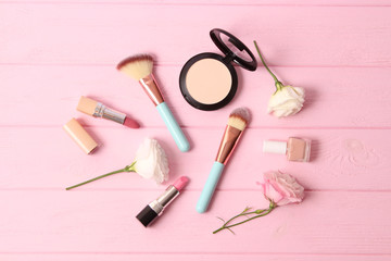 Naklejka premium cosmetics and flowers on a colored background top view.