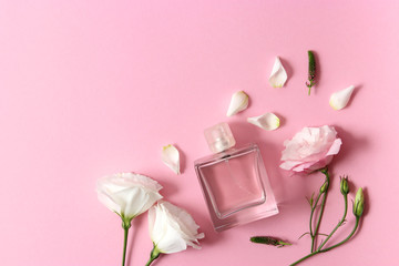 Beautiful composition of flowers and perfumes on a colored background top view