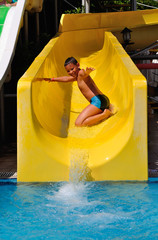Boy riding a water slide on his knees