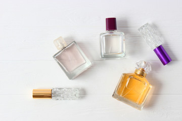 set of different perfumes on a light background top view.