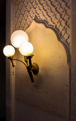 Three bulb lamps, yellow LED lighting elements covered with metal wire frame lampshades, photo with...