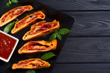 Pizza roll stromboli with cheese salami olives and tomatoes