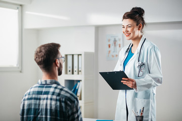 Woman Doctor reads results to Young Patient