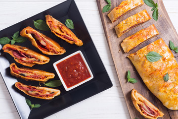 Pizza roll stromboli with cheese salami olives and tomatoes