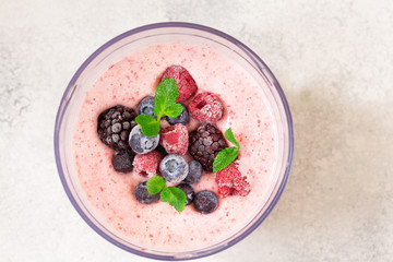 Frozen berries in smoothie in blender bowl top view