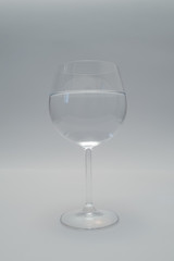 The wine glass with still water on the light background