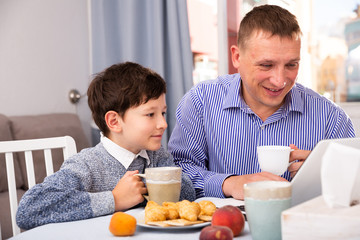 Happy boy with father using laptop