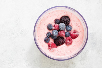 Frozen berries in smoothie in blender bowl top view