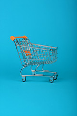 Close up retail shopping cart on blue background