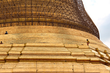 Wooden construction with workers around the golden Shwedagon pagoda in Yangon, Myanmar/Birma.