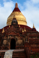 Old pagoda out of red weathered bricks with golden top in Bagan, Myanmar/Birma.