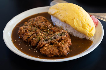 Japanese curry rice with fried beef and omelet.