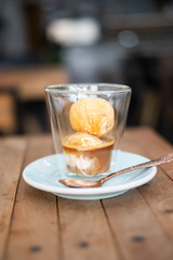 Affogato coffee with ice cream on wooden table.