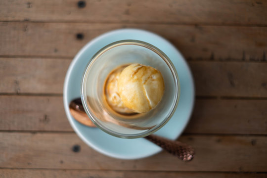 Affogato coffee with ice cream on wooden table.